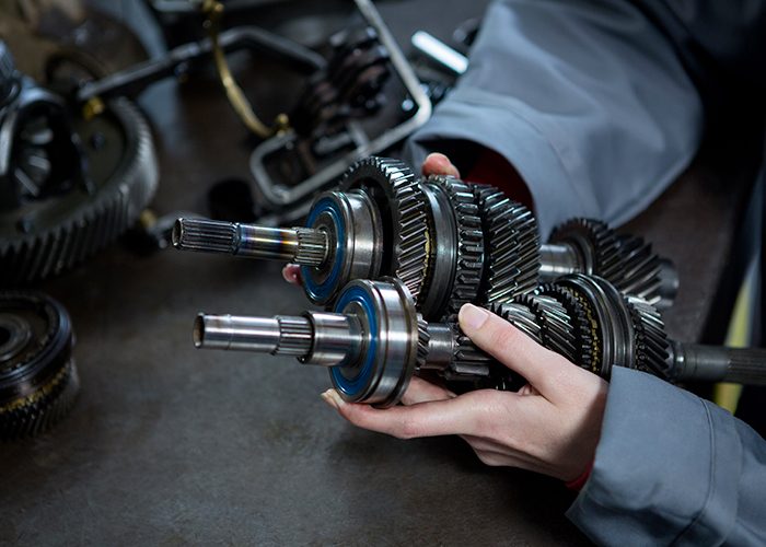 female-mechanic-holding-spare-parts-car